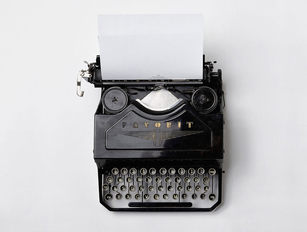 En svart skrivmaskin av den äldre typen att skriva kontrakt med